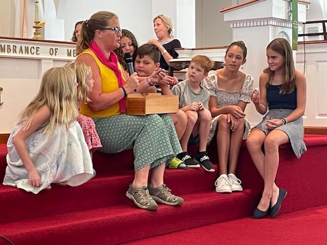 Children gathered around Elder Jen during time with the young church
